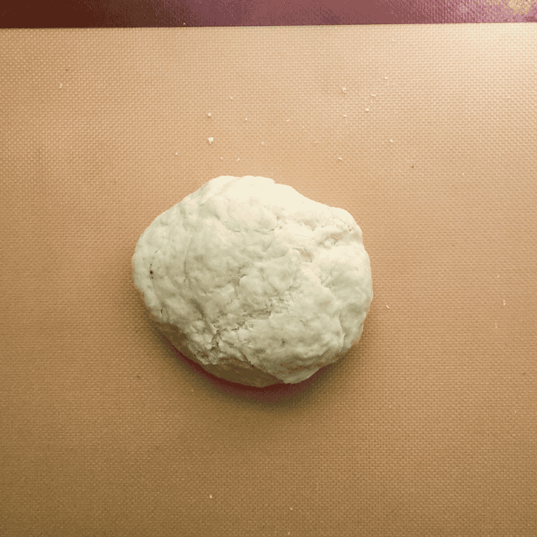 Punching down dough and rolling it out into pizza shape.