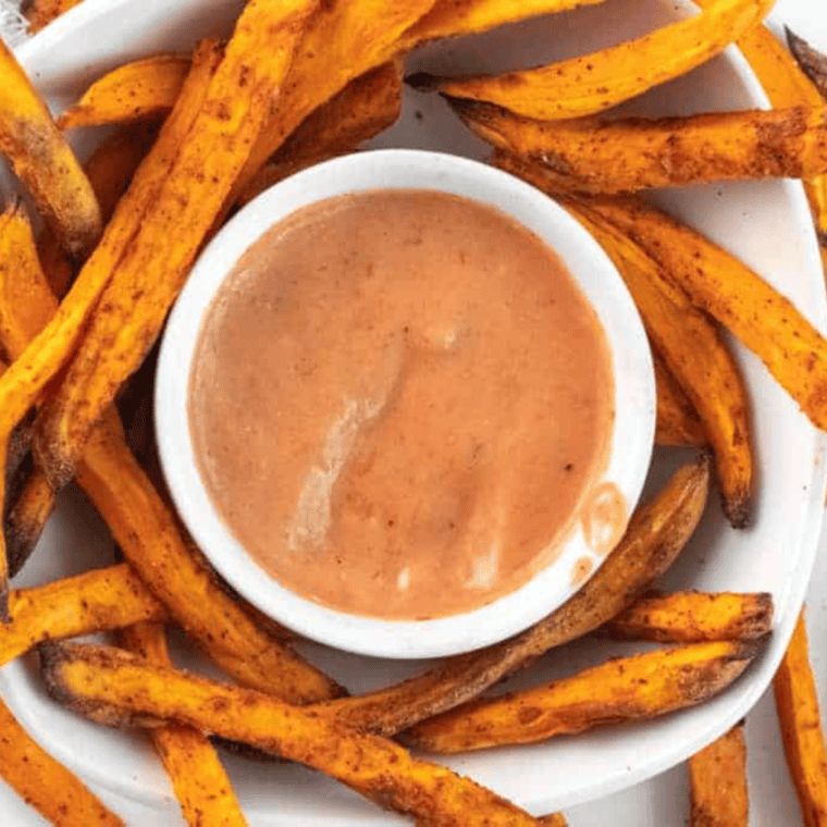 Taco Bell Baja Sauce drizzled over fries, showcasing its creamy texture and zesty flavor.