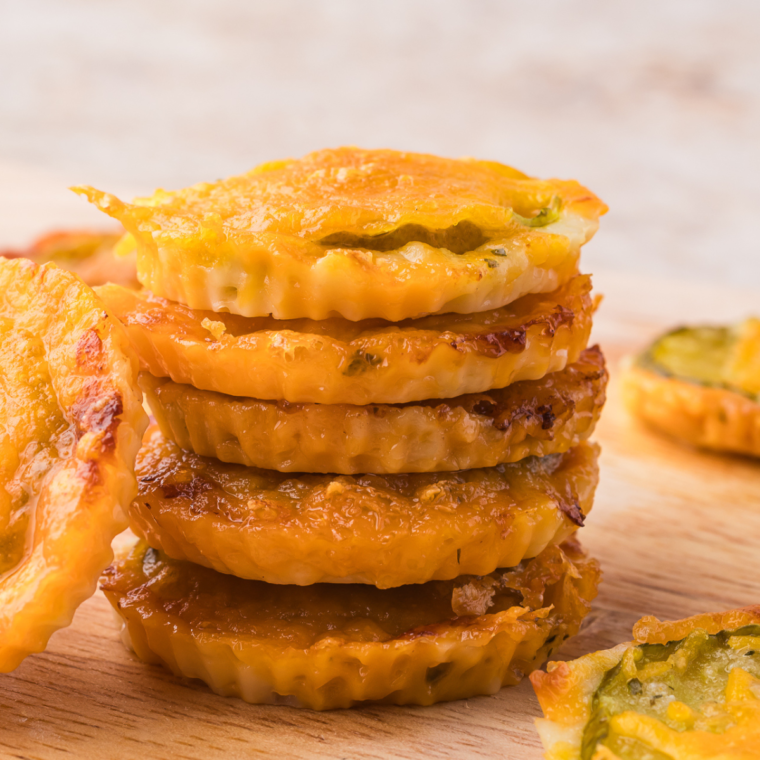 Golden-brown cheddar ranch pickle chips served with a side of ranch dressing.