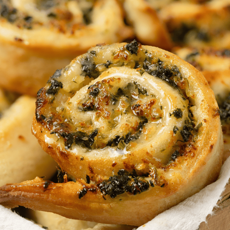 Golden brown air fryer spinach garlic rounds made with puff pastry, stacked on a serving plate