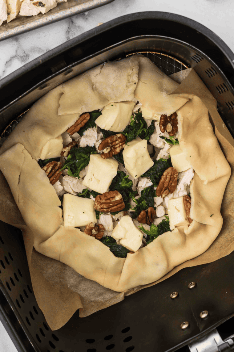 Raw rustic chicken tart in the air fryer basket.