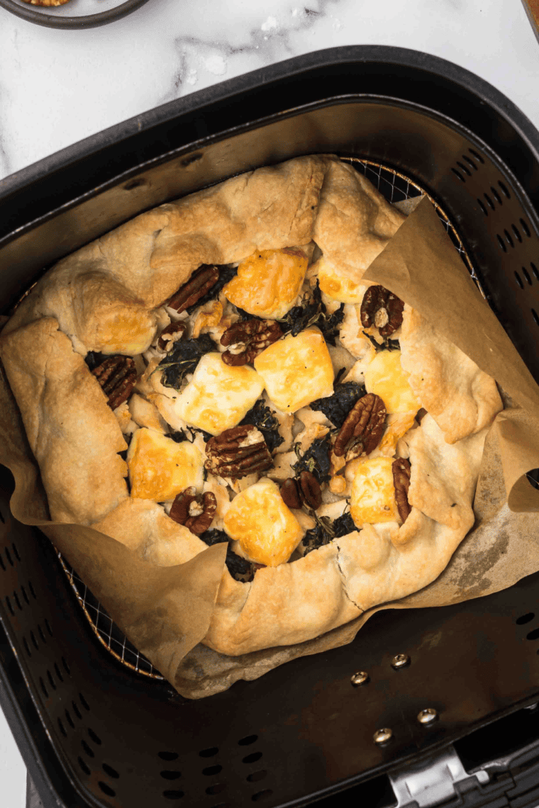 Rustic chicken tart with golden puff pastry, Brie cheese, spinach, and pecans, cooked in an air fryer and served warm