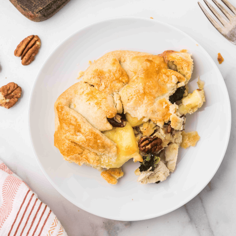 Air fryer rustic chicken tart topped with Brie, spinach, and pecans on a golden, flaky crust