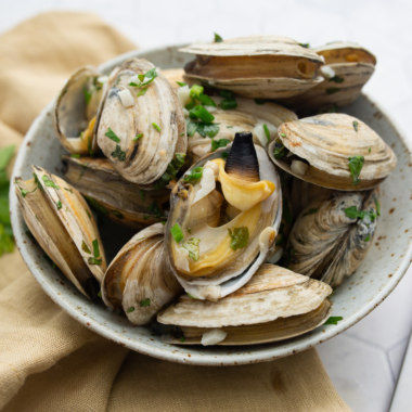 Steamed clams cooked in the air fryer with garlic, butter, and herbs in a foil packet