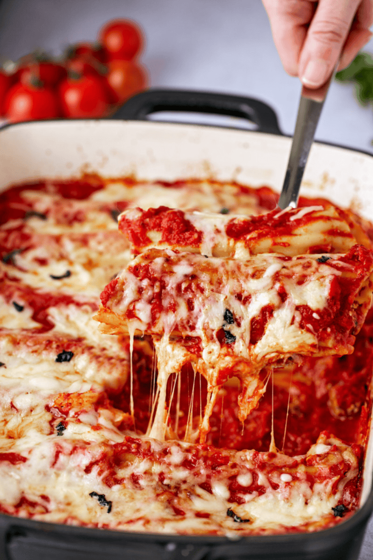 Baked Copycat Olive Garden manicotti topped with marinara sauce and melted cheese.