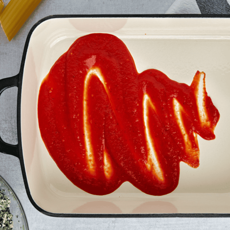Place sauce on the bottom to prevent the manicotti from sticking to the baking pan.