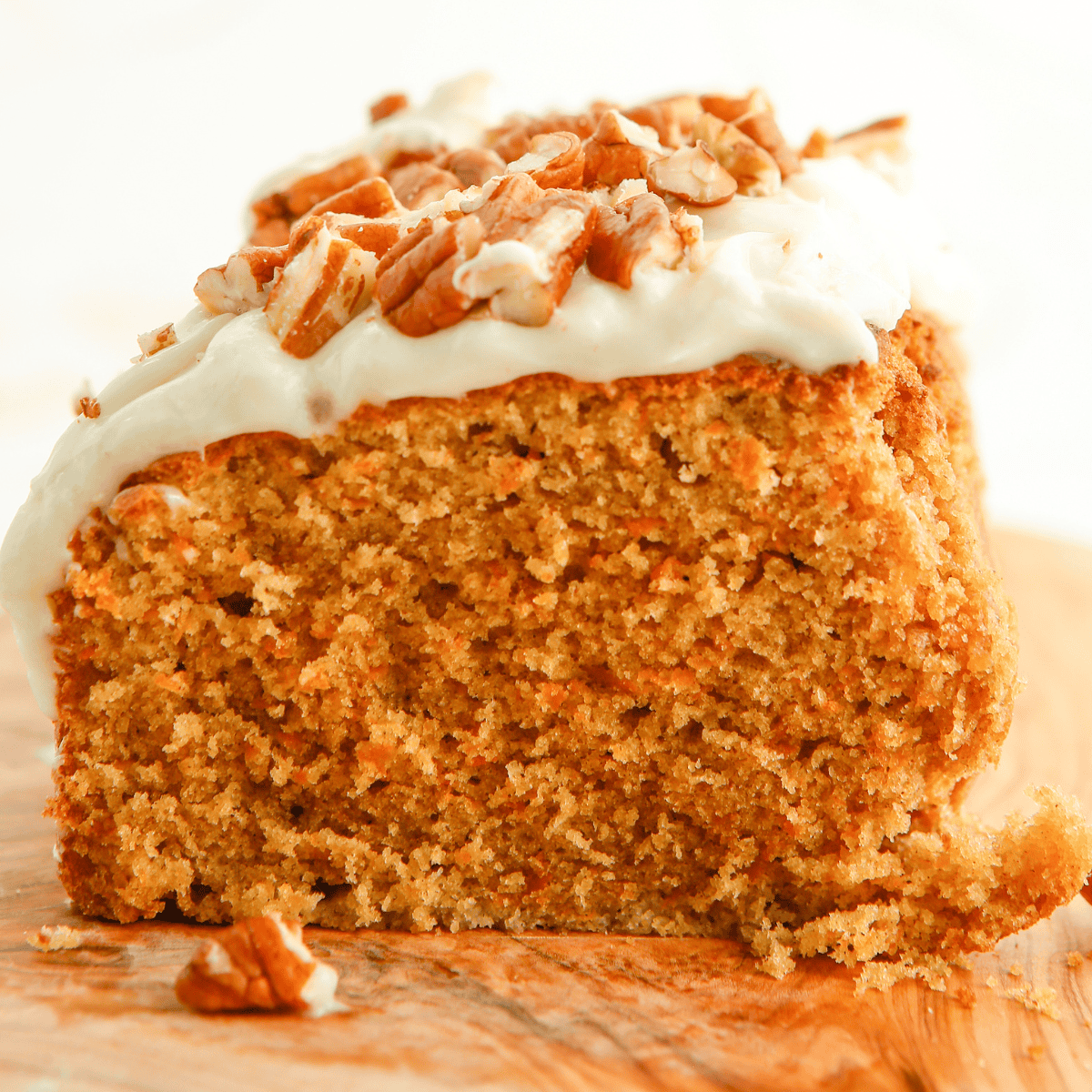 Slice of Copycat Cracker Barrel Carrot Cake topped with cream cheese frosting and chopped nuts.