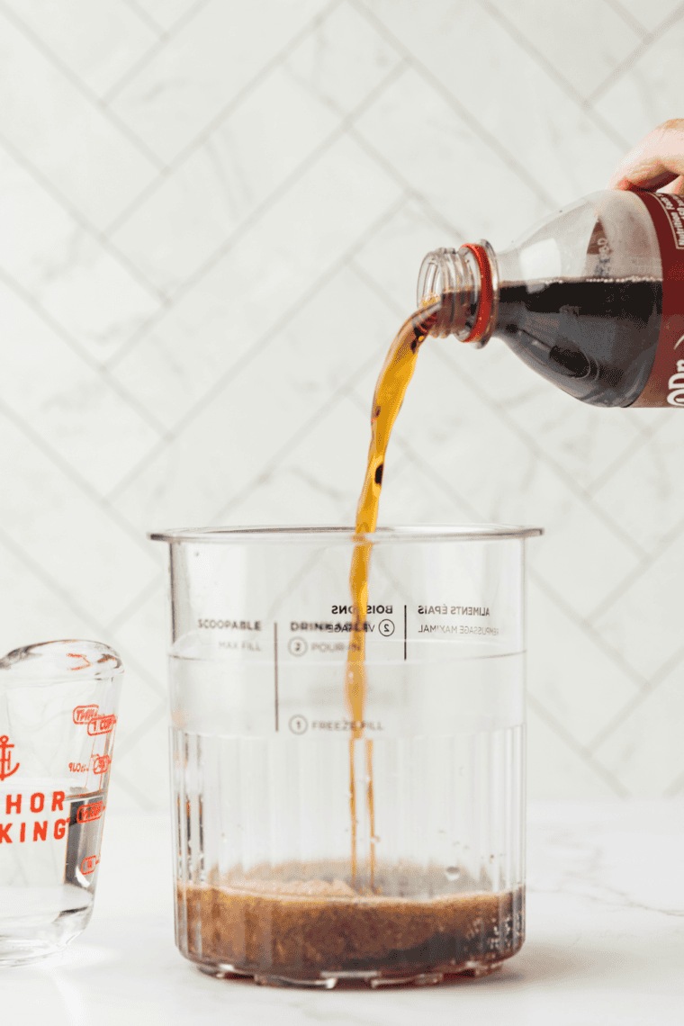 Mixing Dr Pepper, coconut extract, and lime juice in a Ninja Creami pint container up to the "Drinkable Freeze Fill" line