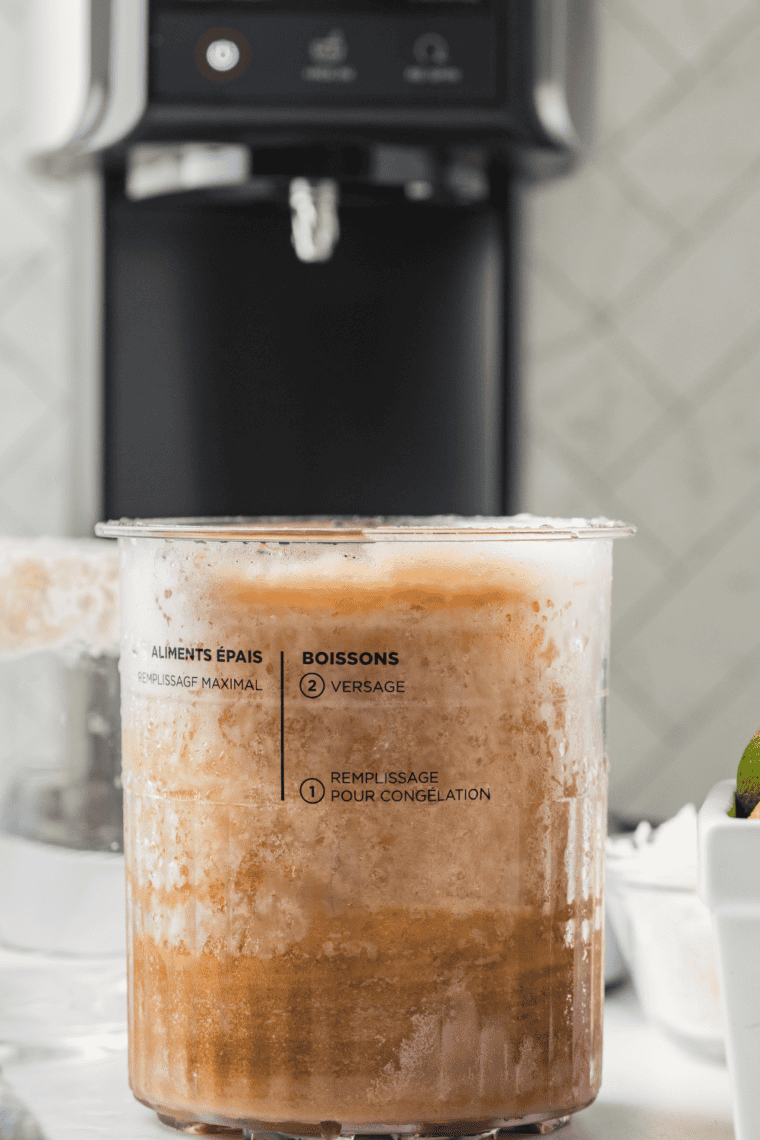 Ninja Creami pint with water added, placed into machine with Creamerizer™ Paddle installed, ready to run Slushie function