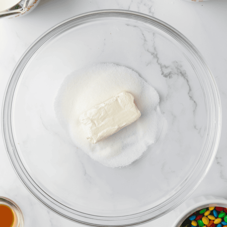Mixing softened cream cheese, sugar, and vanilla extract together in a bowl until smooth and creamy