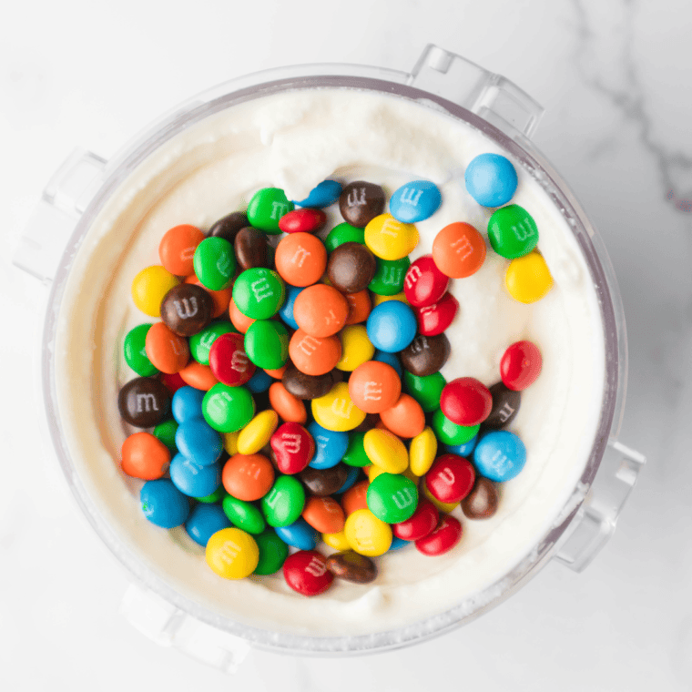 Adding mini M&M’s into the center of processed ice cream and placing the pint back into the Ninja Creami to mix in the candies
