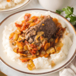 Ninja Foodi Beef Osso Buco served with vegetables and rich sauce on a white plate.
