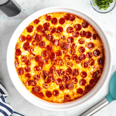 Cheesy air fryer pepperoni pierogy pizza casserole served in a dish with golden edges and melted cheese.