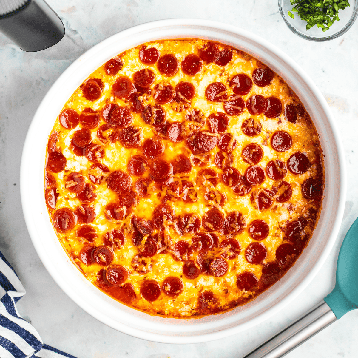 Cheesy air fryer pepperoni pierogy pizza casserole served in a dish with golden edges and melted cheese.