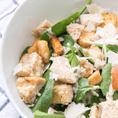 Spicy Caesar Salad with crisp romaine, spicy dressing, and crunchy croutons, garnished with Parmesan cheese.
