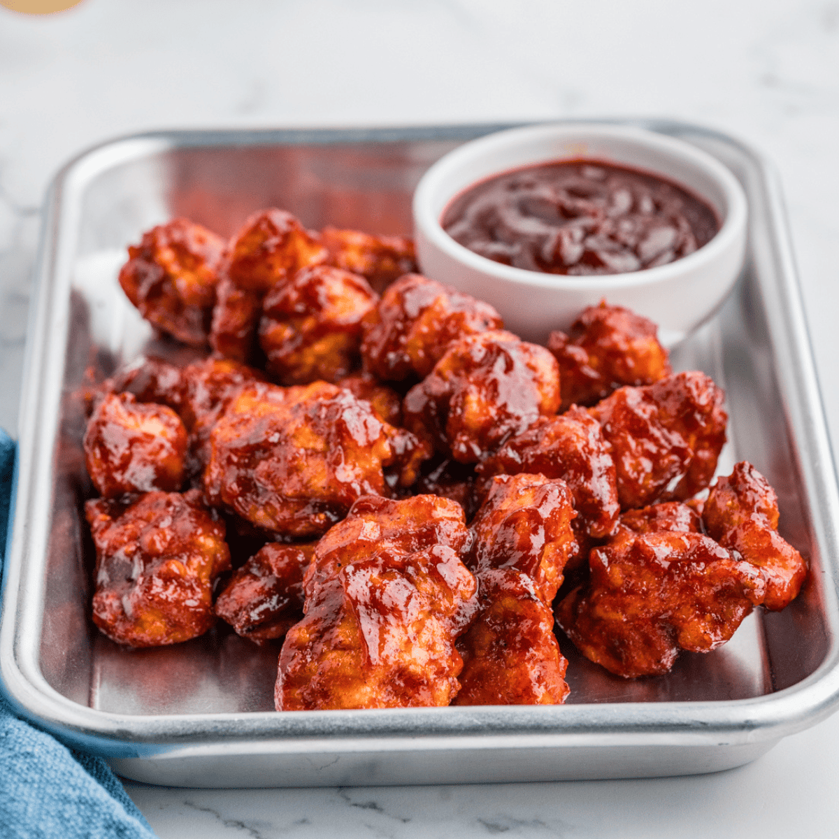Jar of Sweet Honey Bourbon BBQ Sauce with a basting brush and fresh ingredients nearby.