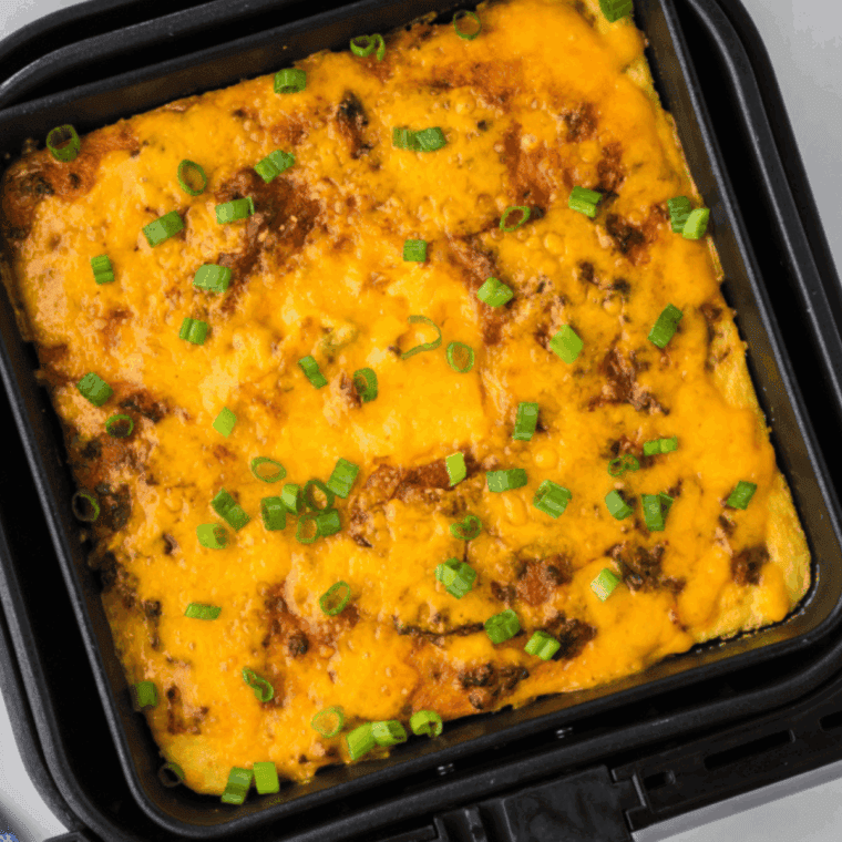 Cheesy air fryer cheeseburger casserole with ground beef and pasta in a baking dish, topped with melted cheddar cheese.