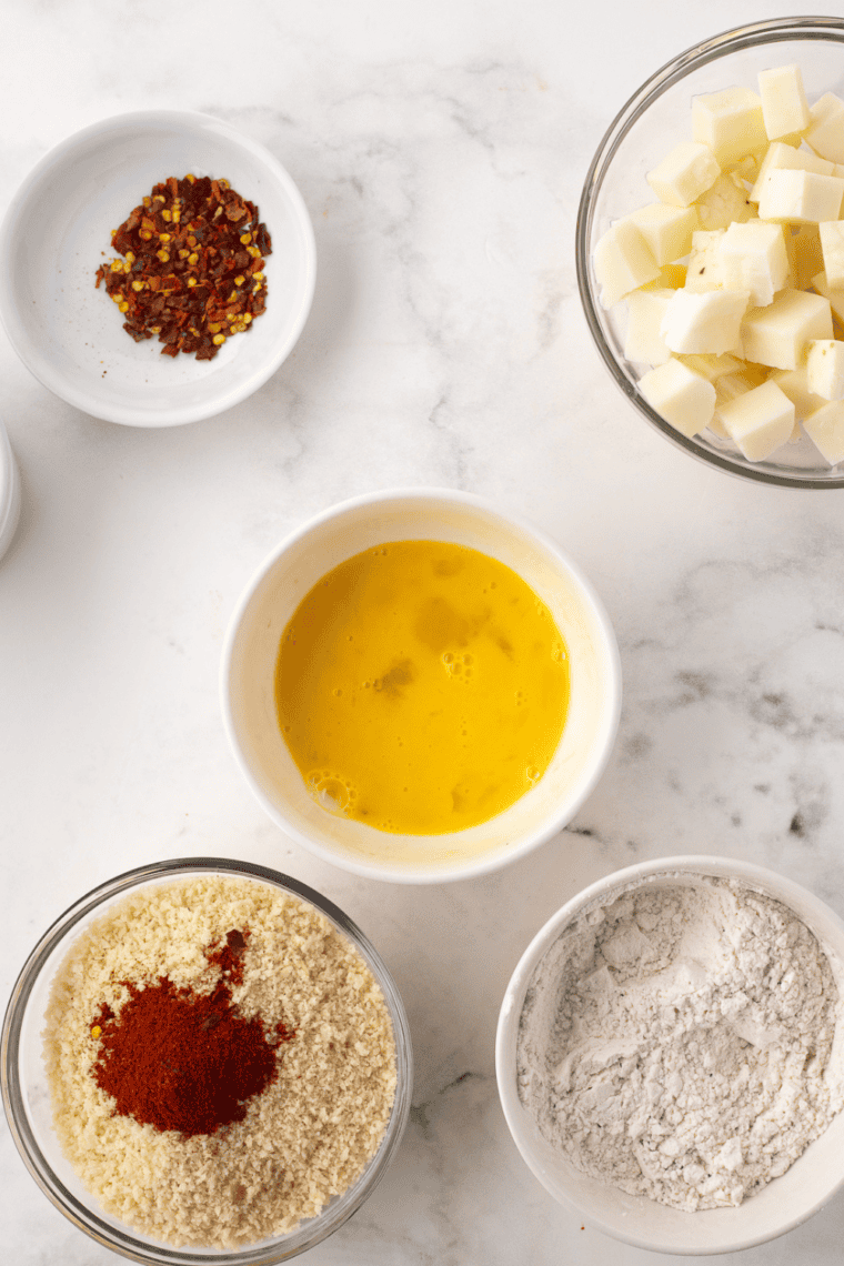 Setting up breading station with flour, beaten egg, and breadcrumb mixture.