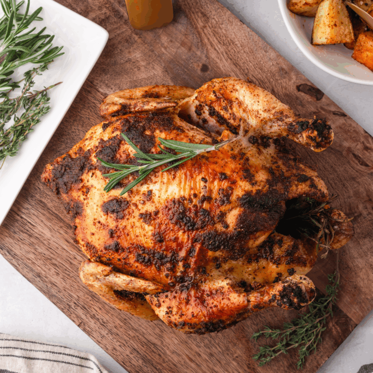 Crispy, golden air fryer whole chicken cooked from frozen, resting in the air fryer basket.