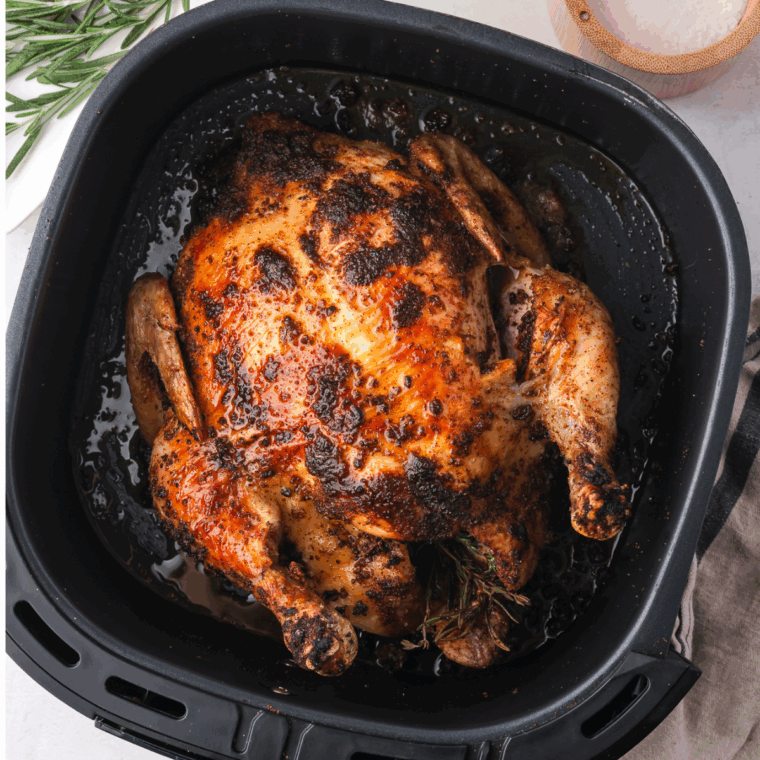 Crispy, golden whole chicken cooked in the air fryer from frozen, served on a platter.