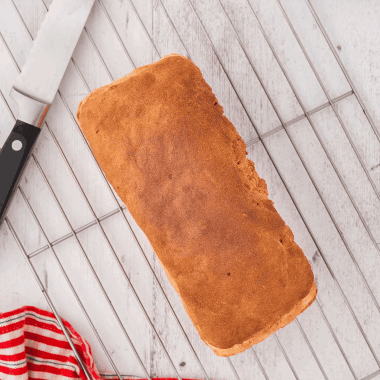 Cooked loaf of Air Fryer Gluten-Free Bread on the kitchen cooling rank.