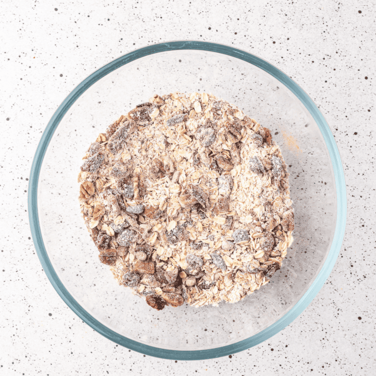 Mixing oats, chopped nuts, dried fruit, cinnamon, and salt in a large bowl.