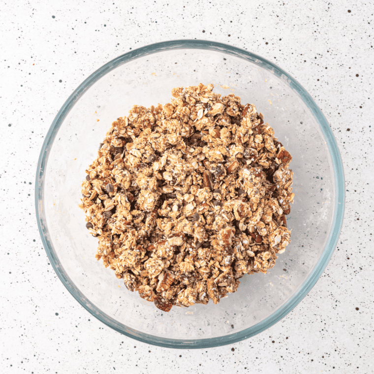 Warming honey and peanut butter in a microwave-safe bowl, then mixing in vanilla extract and pouring over dry ingredients.