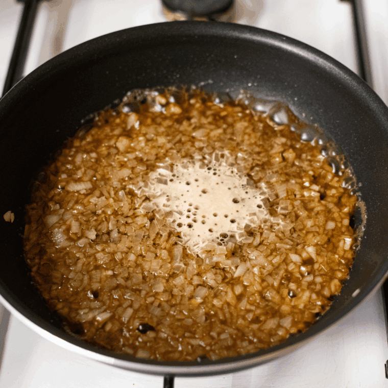 Cooking finely chopped onion in oil, adding Guinness beer to simmer and reduce.