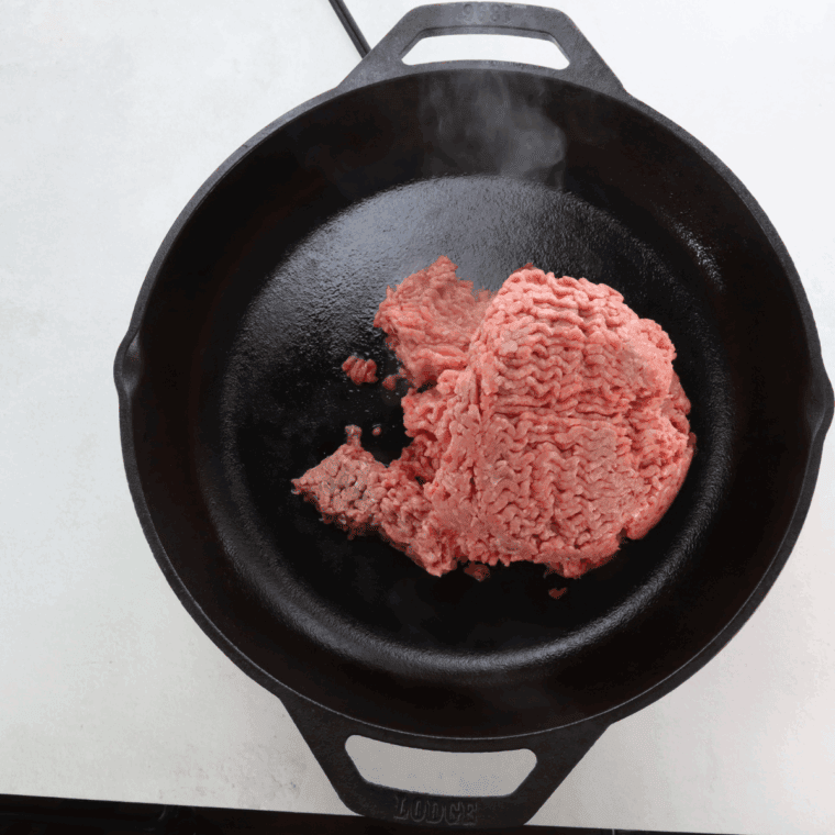 Cooking ground beef in a cast iron pan.