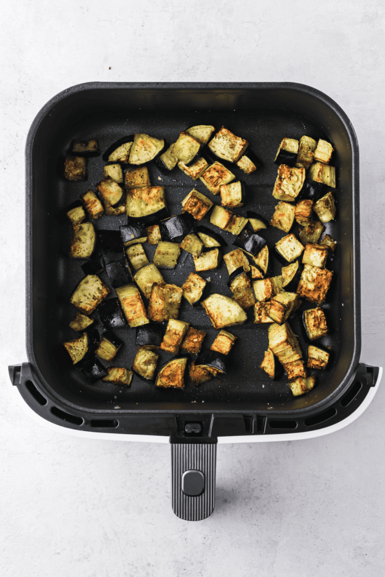 Cooked eggplant in the air fryer basket.