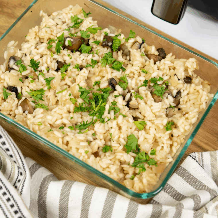 Bowl of creamy air fryer risotto topped with fresh herbs and Parmesan.