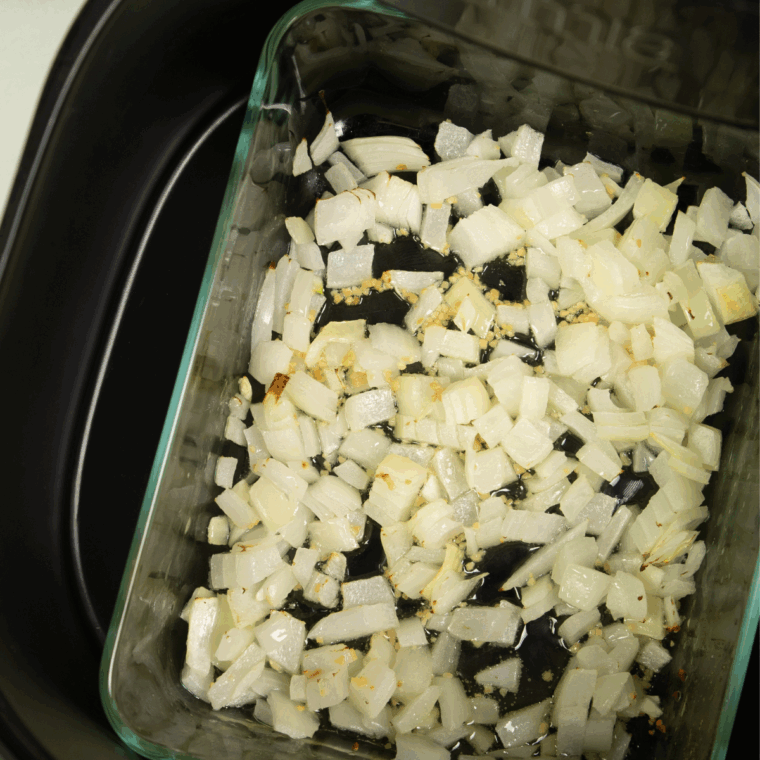 Chopped onions and minced garlic on a cutting board.