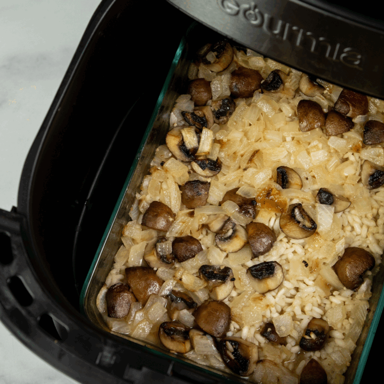 Risotto rice stirred into the buttery mushroom mixture in the air fryer.