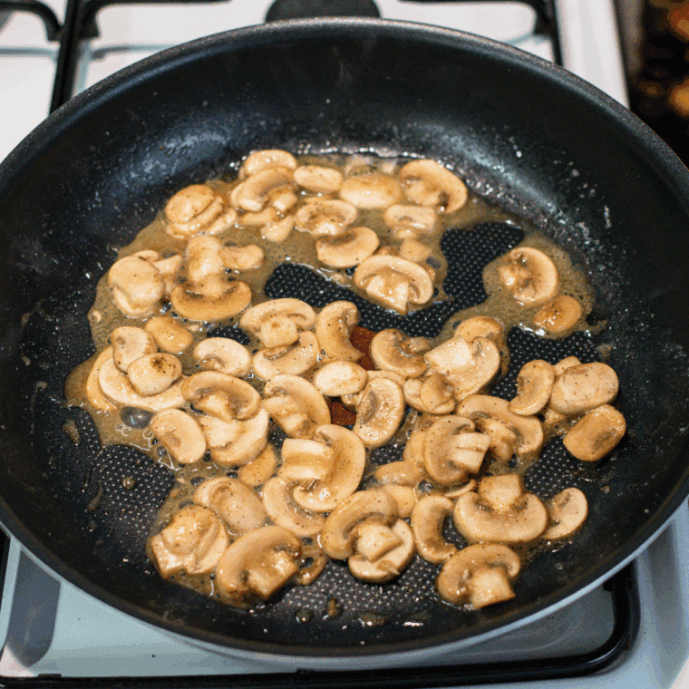 Melting butter in a skillet, cooking mushrooms until browned and tender.