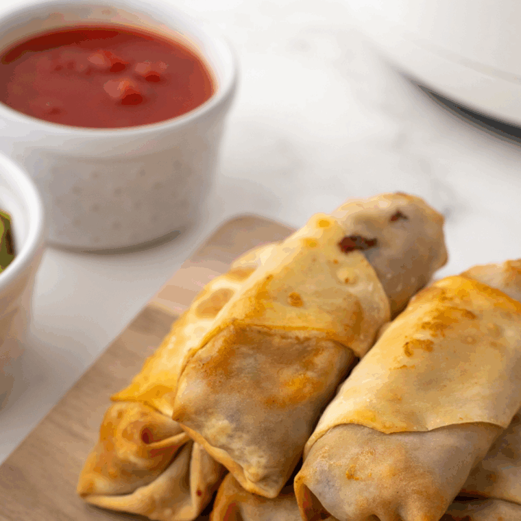 Air Fryer Taco Egg Rolls, golden and crispy, stuffed with seasoned beef, cheese, and taco fillings.