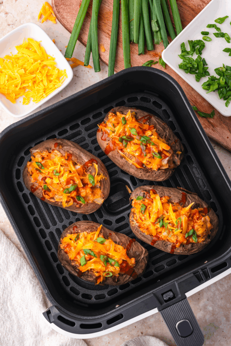 Air Fryer Twice Baked Buffalo Chicken Potatoes filled with spicy buffalo chicken, cheese, and crispy golden tops.