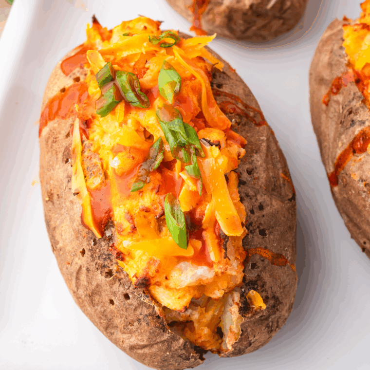 Delicious Air Fryer Twice Baked Buffalo Chicken Potatoes with buffalo chicken filling and crispy, cheesy topping.