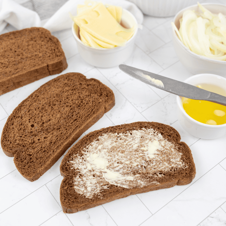 Dividing ground beef into patties and buttering rye bread.