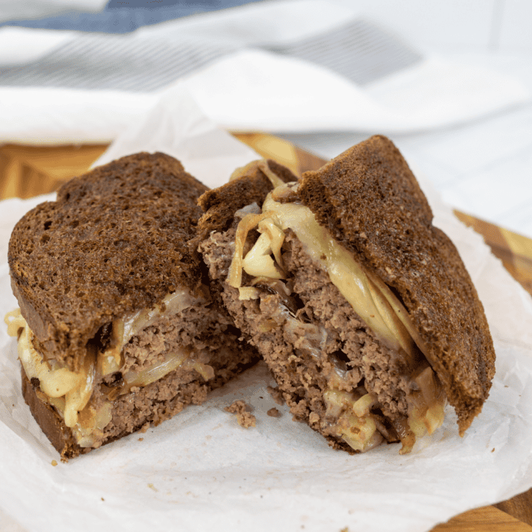 Cut Blackstone Patty Melt on kitchen table cutting board.