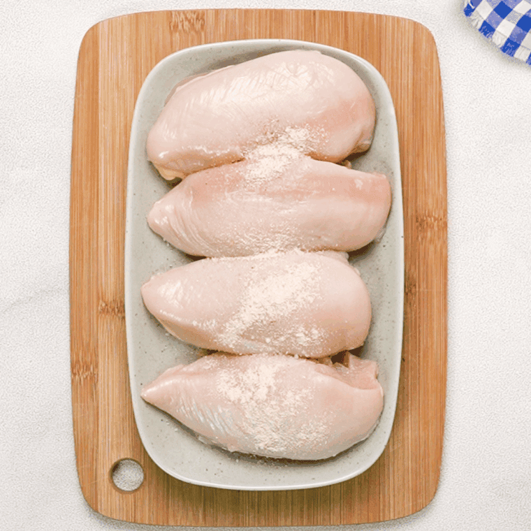 Seasoned chicken breasts with salt, pepper, and garlic powder, ready for air frying.