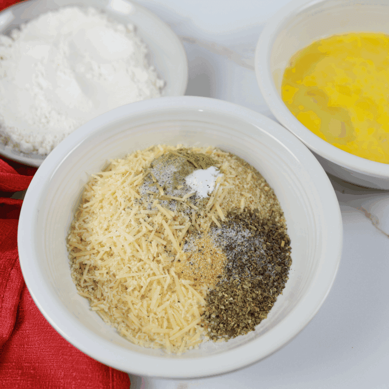 Drizzling olive oil into the breadcrumb mixture to moisten it.