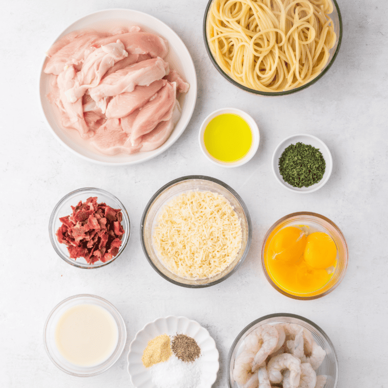 Ingredients needed for Copycat Olive Garden Chicken and Shrimp Carbonara on kitchen table.