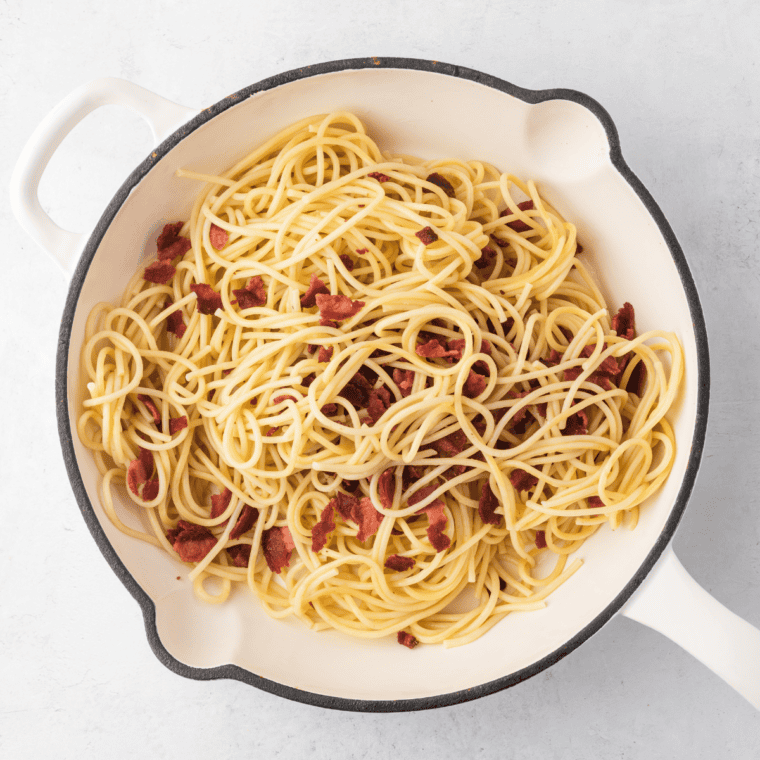 Drain the pasta in a strainer, add the diced bacon.
