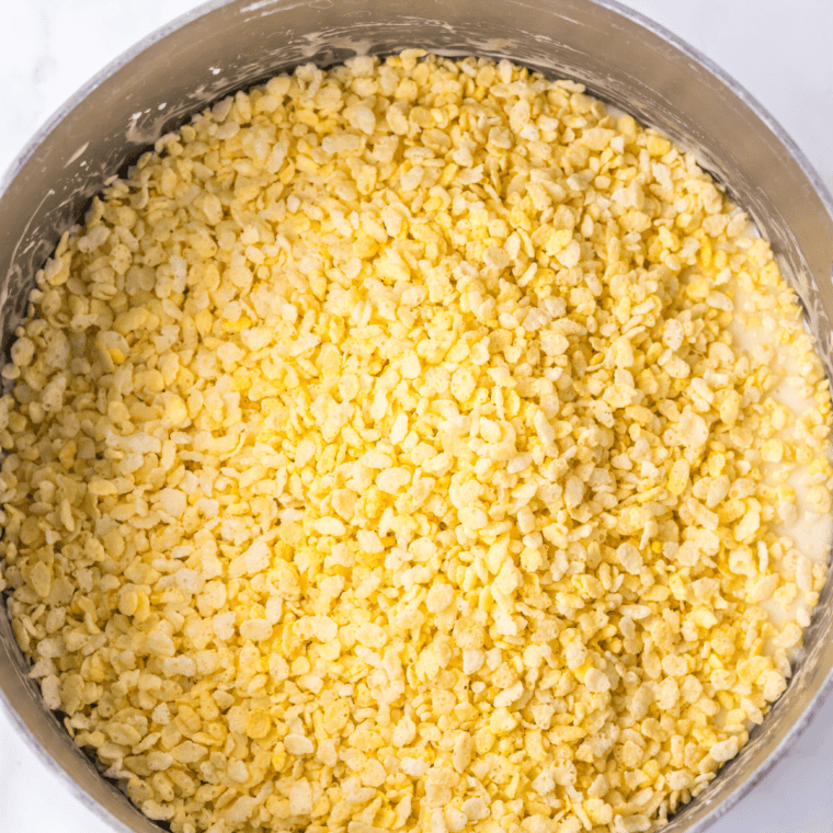Mixing Rice Krispies cereal with the marshmallow mixture until fully coated.