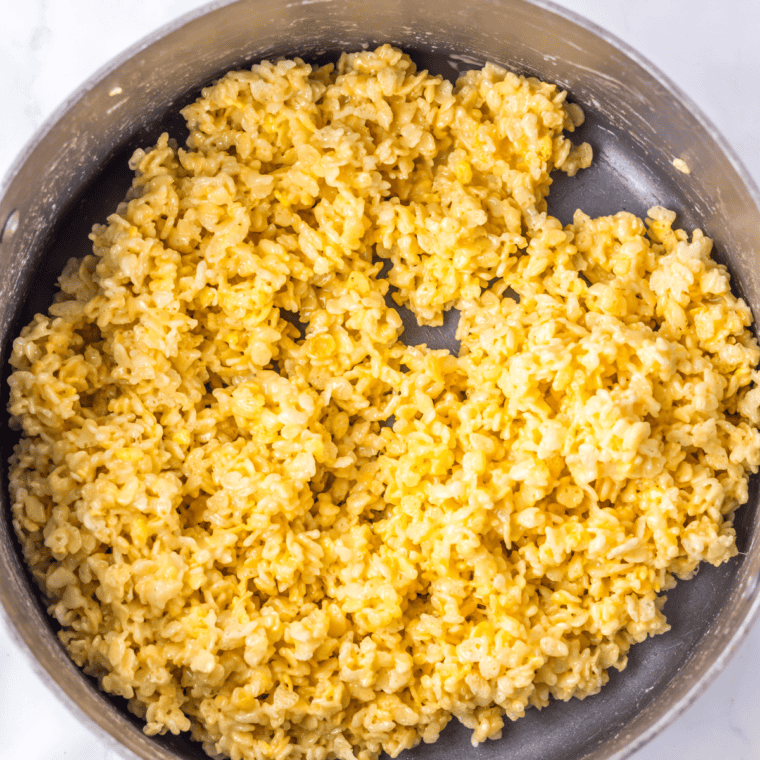 Pressing the Rice Krispie mixture into a greased 9x13-inch baking pan.
