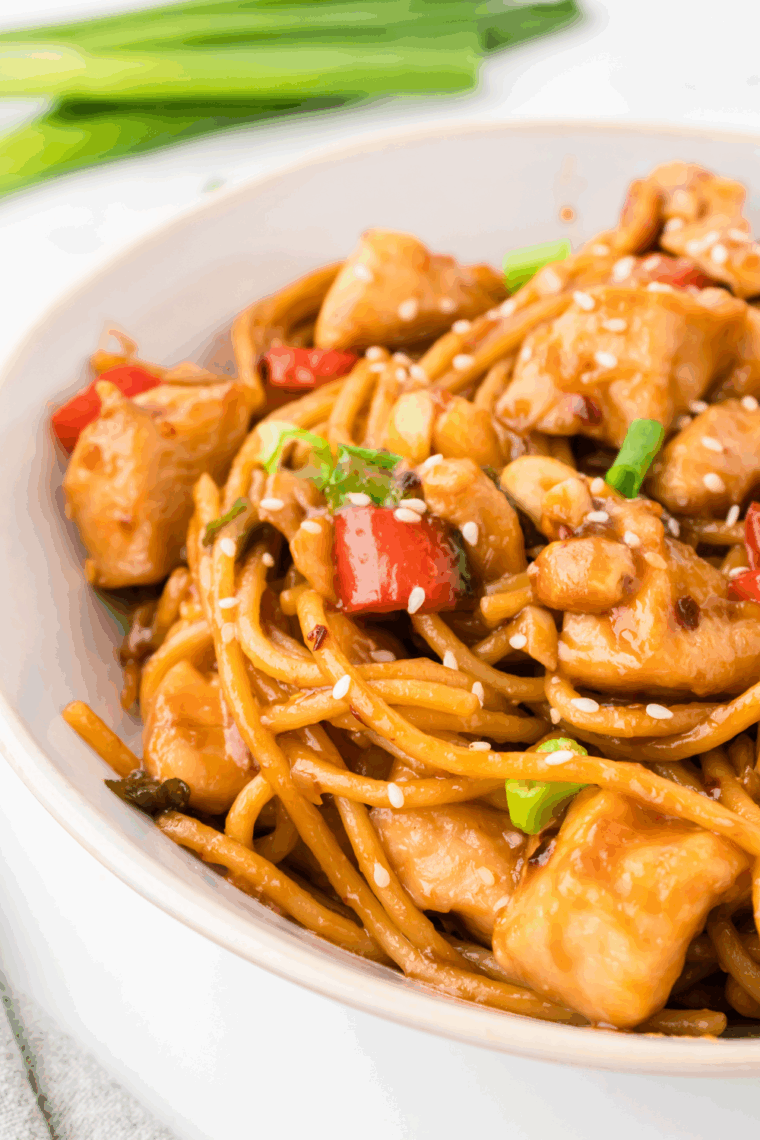 A serving of Kung Pao Chicken Spaghetti, featuring tender chicken, vegetables, and spaghetti coated in a flavorful, spicy sauce.