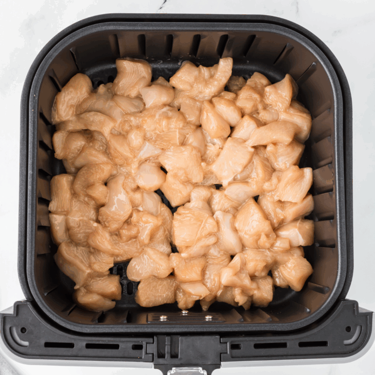 Marinate the chicken with soy sauce and cornstarch, then place it in the air fryer basket and cook at 375°F.