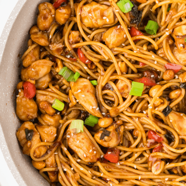 A plate of Kung Pao Chicken Spaghetti with tender chicken, spicy sauce, and vibrant vegetables.