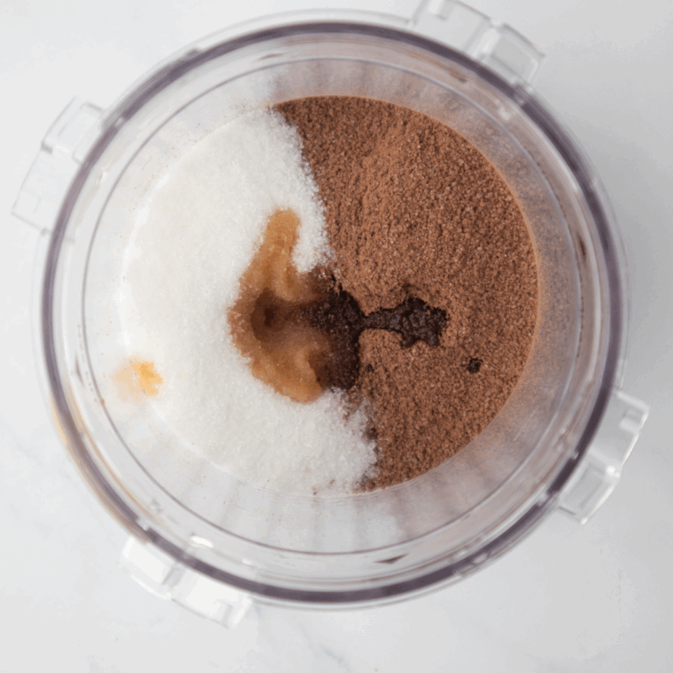 Mixing milk, cream, Nutella, and other ingredients in a Ninja Creami pint container with a whisk.