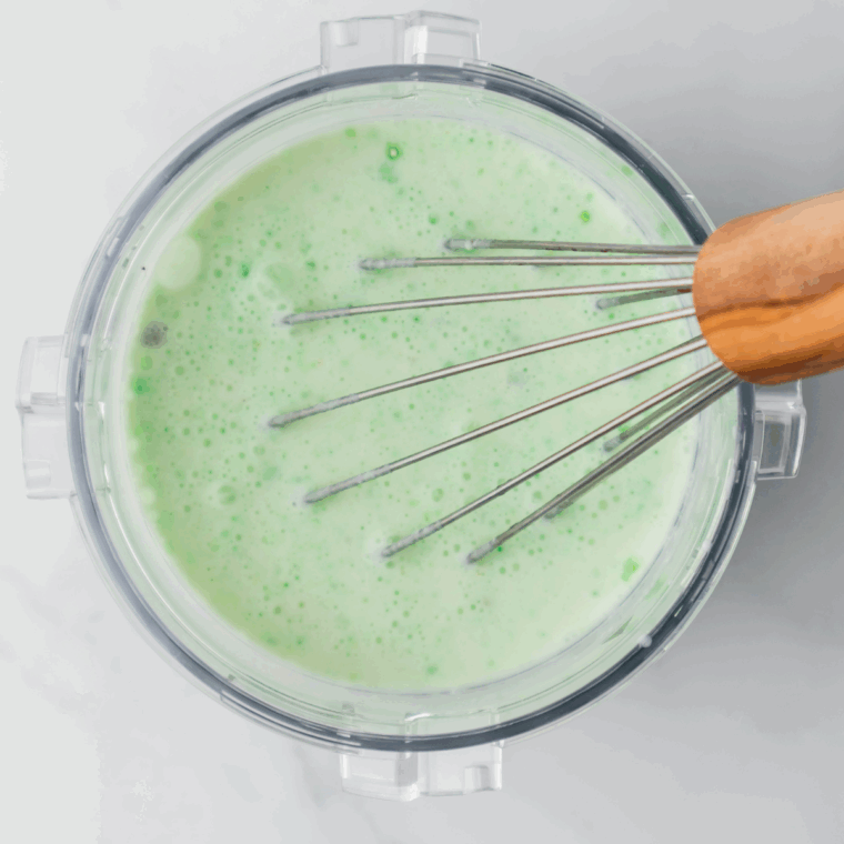 Mixing milk, heavy cream, and dry pistachio pudding mix in a Ninja pint bowl until fully dissolved.
